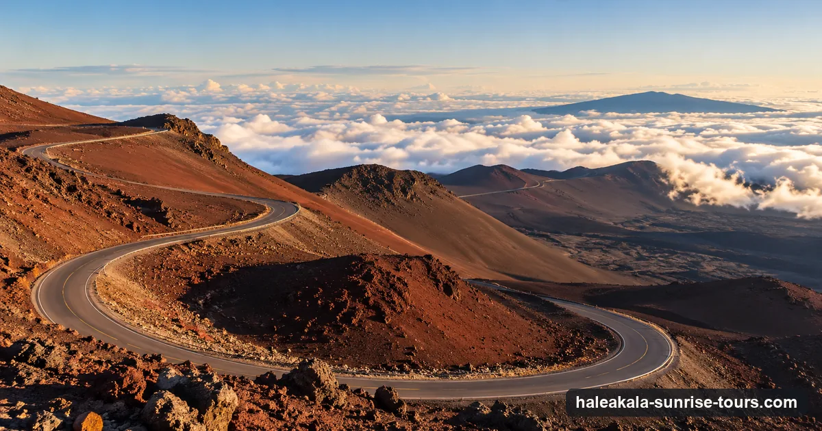 Switchbacks of the summit road climbing reddish volcanic slopes on Haleakalā above the clouds