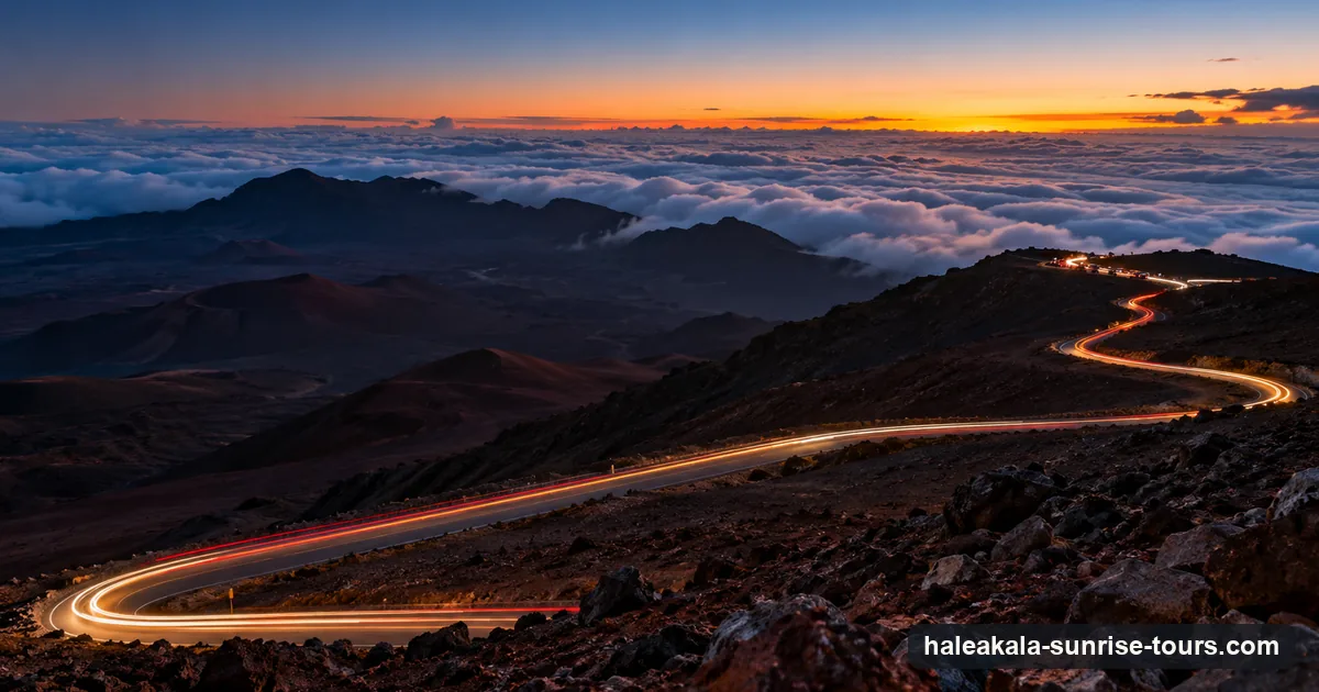 Car headlights winding up the switchbacks of Haleakalā before dawn, above the clouds